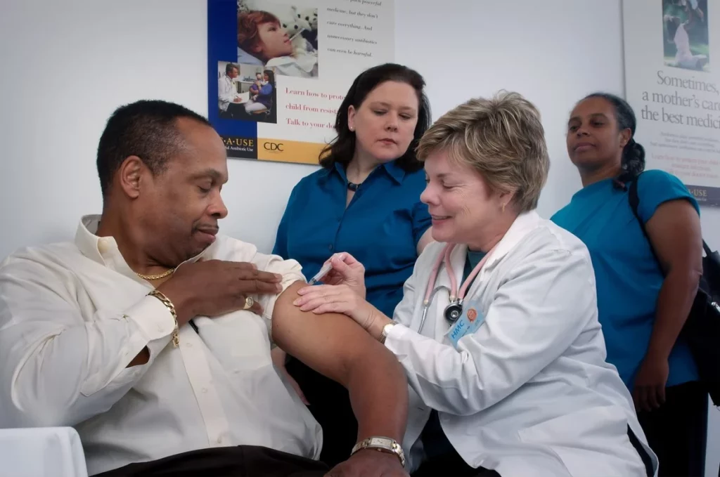 doctor giving middle aged man a vaccine